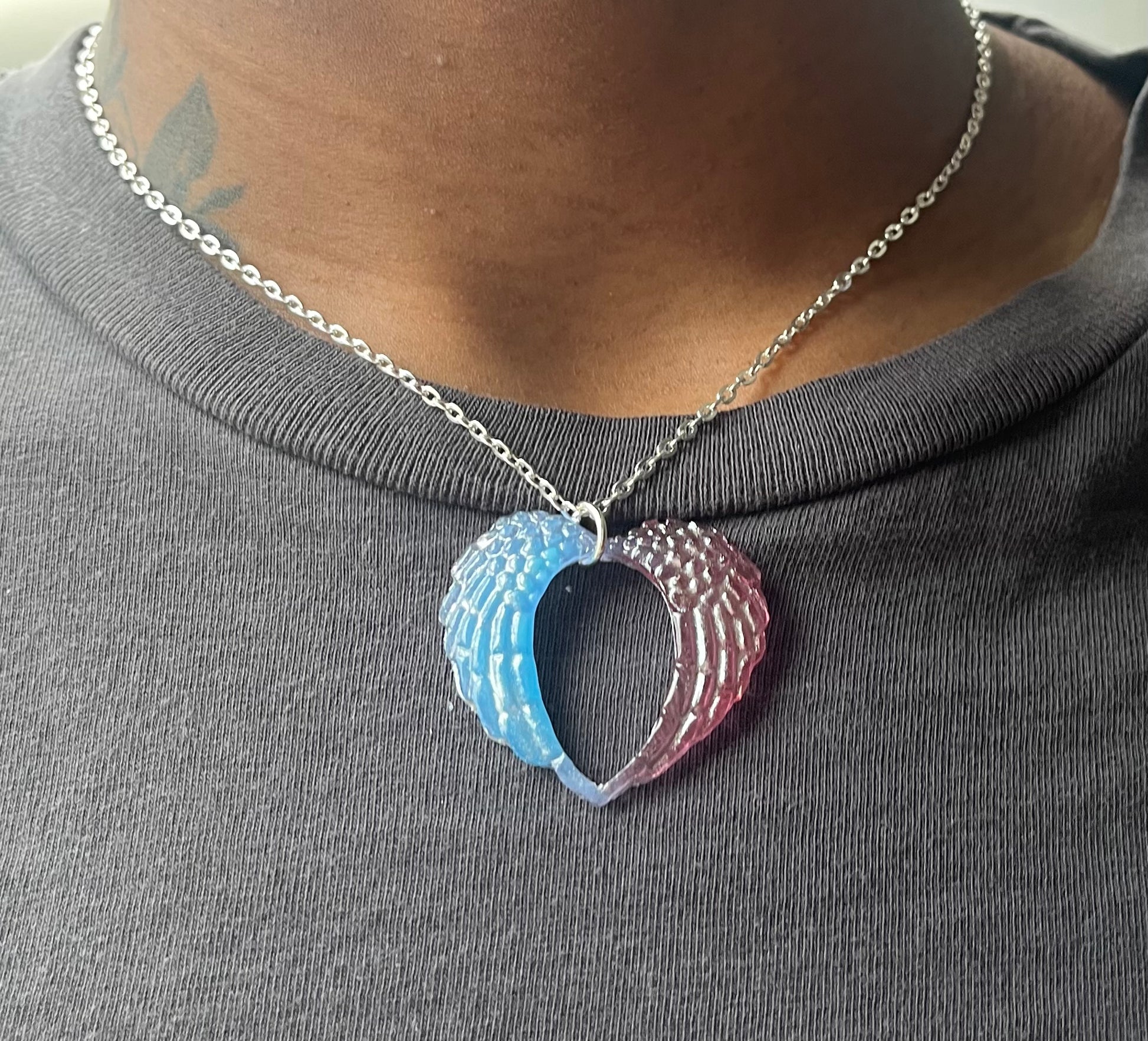 closeup shot of angel wing heart necklace being modeled